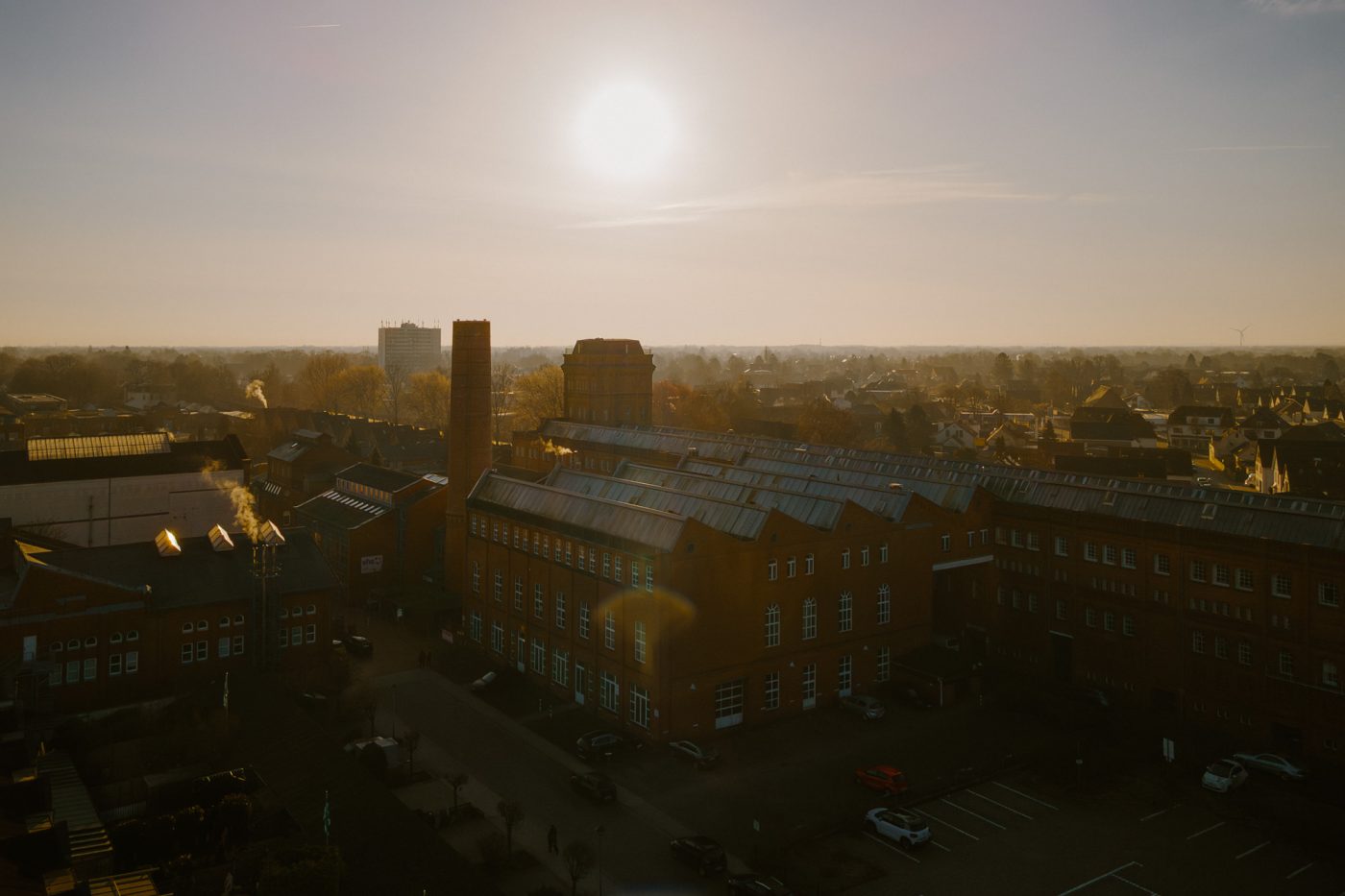 Luftbild des Nordwolle-Geländes bei Sonnenaufgang. Im Zentrum ist das Technologie- und Wirtschaftszentrum zu sehen